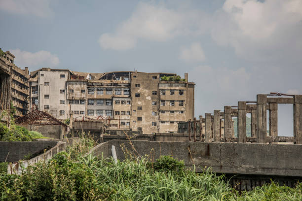 Battleship Island (Gunkanjima, Hashima, Gunkanjima, Gunkanjima, Gunkanjima) Hashima Island (端島 or simply Hashima — -shima is a Japanese suffix for island), commonly called Gunkanjima (軍艦島; meaning Battleship Island), is an abandoned island lying about 15 kilometers (9 miles) from the city of Nagasaki, in southern Japan. It is one of 505 uninhabited islands in Nagasaki Prefecture. The island's most notable features are its abandoned concrete buildings, undisturbed except by nature, and the surrounding sea wall. While the island is a symbol of the rapid industrialization of Japan, it is also a reminder of its dark history as a site of forced labor prior to and during the Second World War. mitsukejima island photos stock pictures, royalty-free photos & images