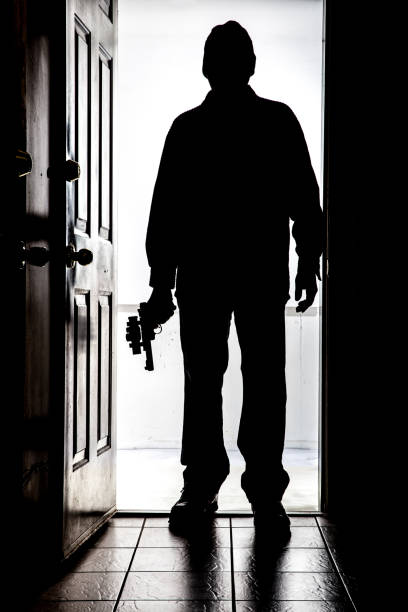 istock Intruder at door, in silhouette with handgun 830007956