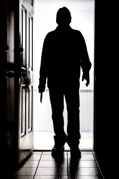 intruder at door, in silhouette with buck knife - domestic violence imagens e fotografias de stock