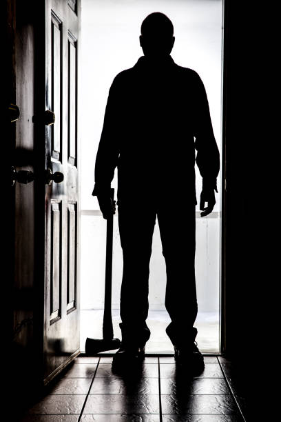 istock Intruder at door, in silhouette with axe 830008050