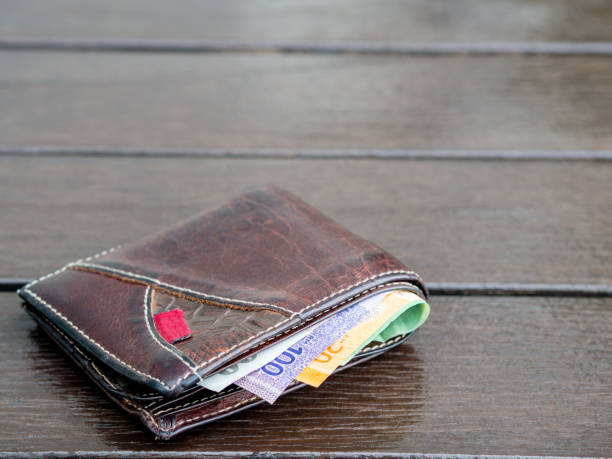 istock Lost leather wallet with money on empty bench, lost money concept, copy space on top. 830032772