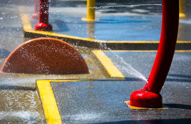 Closeup of water spraying from rings at urban splash pad childrens park - Stock image
