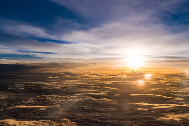 istock Aerial view from airplane flying above the clouds , Twilight time with sunset flare 830052266