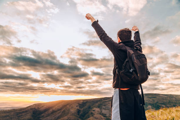 istock Young man cheering on top of mountain 830058182