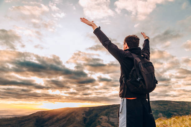 istock Young man cheering on top of mountain 830058204
