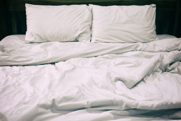 istock Messy white bed and pillow, in the morning 830070514