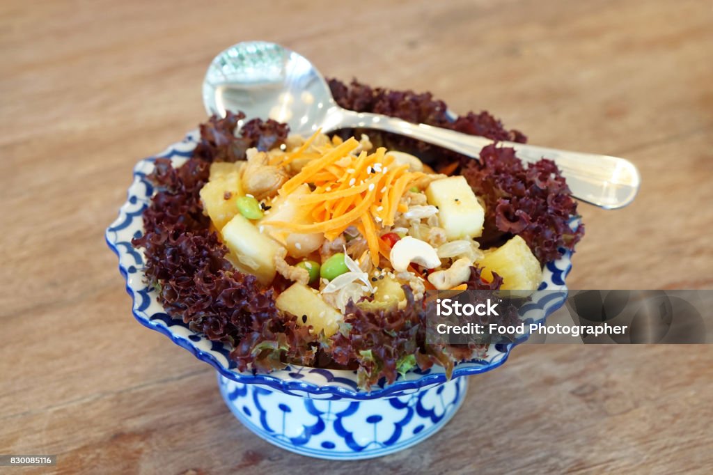 Spicy fruit salad mixed with pomelo, pineapple, cashew nuts, green bean (edamame) decorated with carrot and sesame seeds - Veganism Food is the practice of abstaining from the use of animal products. Antioxidant Stock Photo