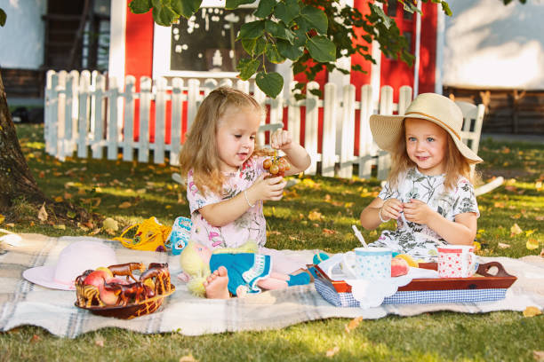 istock Two little girls sitting on green grass 830138244
