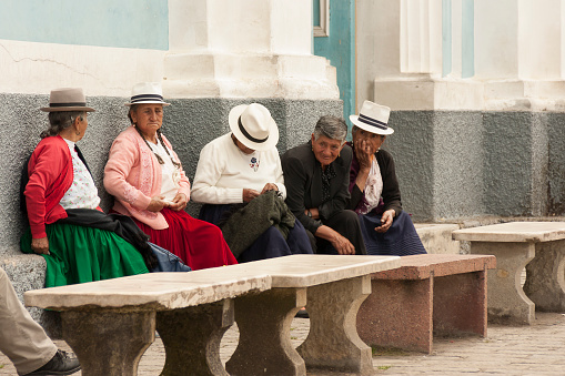 Cuenca, Ecuador - February 24, 2013: Andean indigenous aged people peacefully sitting on a street in the andean town Baños of Cuenca. Most indigenous people in this area are Inca descendants and are usually active and productive even after an advanced age.
