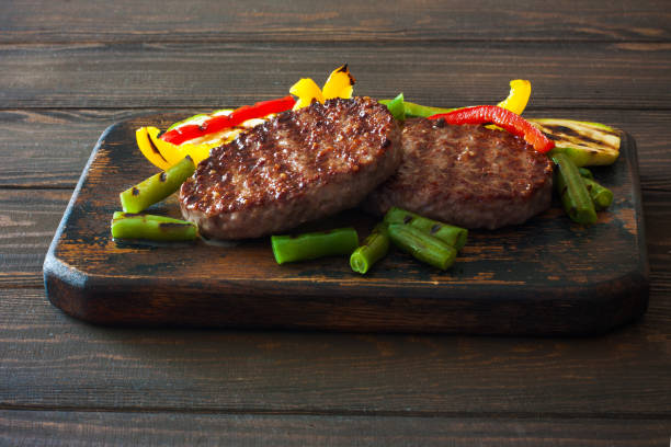 istock Beefsteak grilled with vegetables on a dark wood background 830163032