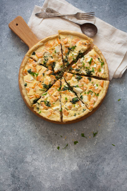 istock Pie ( quice) with salmon, spinach and soft cheese on a grey stone background 830170962