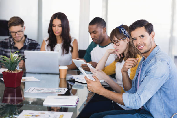 istock Portrait of creative businessman with team working at office 830180330