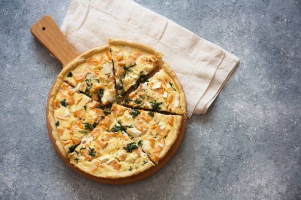 istock Pie ( quiche) with salmon, spinach and soft cheese on a grey stone background 830185158