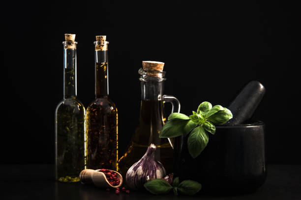 Infused olive oils, herbs and spices on dark stone background