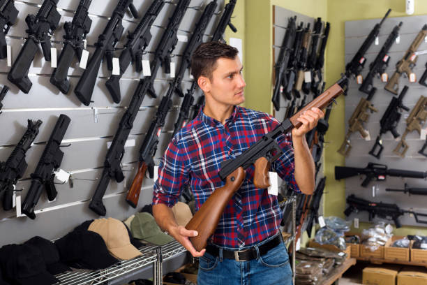 istock Guy choosing air rifle in military store 830192738