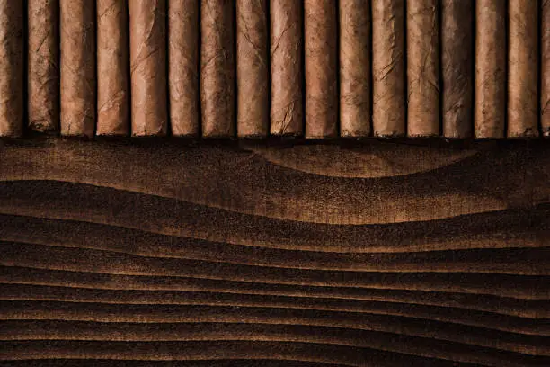 Cuban cigars close up on wooden table, border background. Directly from above top view