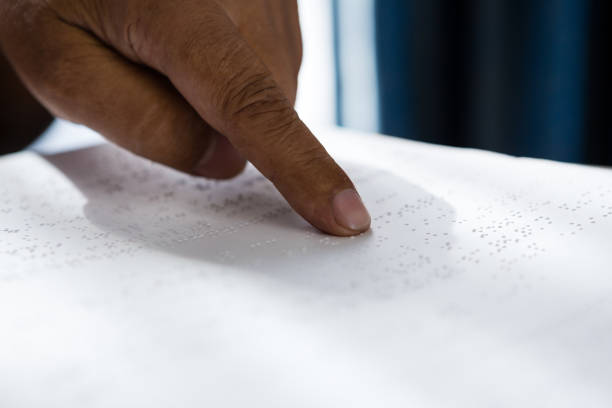 istock Cropped hands on man reading braille book in retirement home 830200590