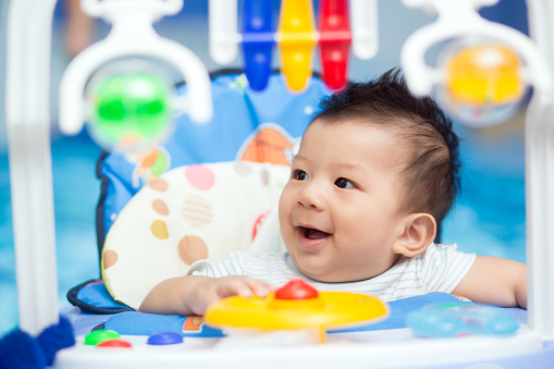 Portrait of a happy baby playing with toys.