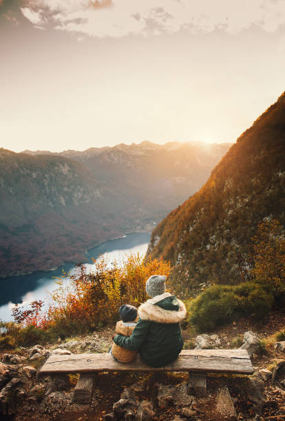 mother with son looking at sunset in mountains. - julian alps lake bohinj lake bohinj imagens e fotografias de stock
