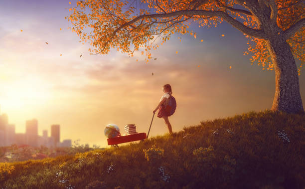 istock child standing with books near tree 830231576