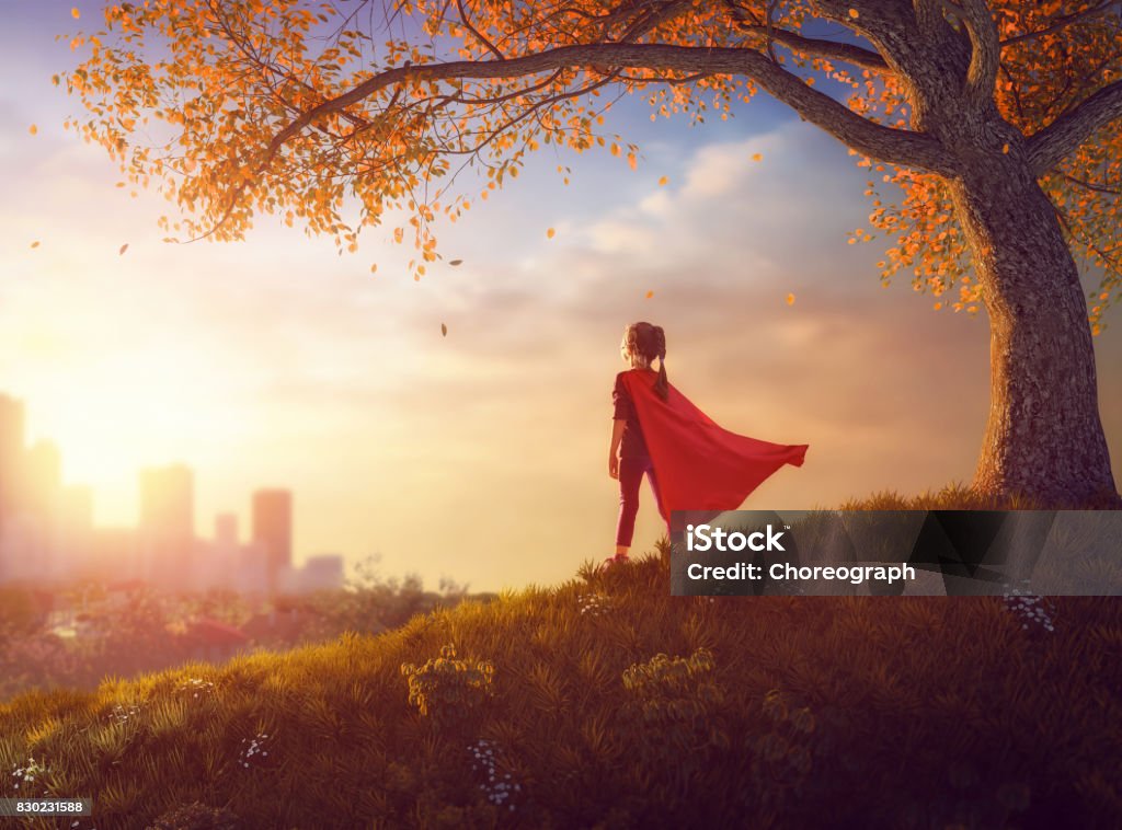 child is playing superhero Little child is playing superhero. Kid on the background of autumn landscape. Girl power concept. Child Stock Photo