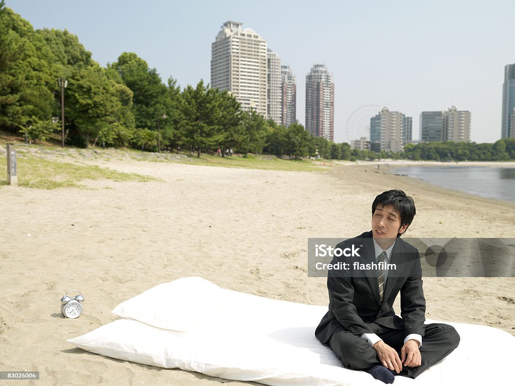 Japanese bussiness man sitting on futon, at beach  Beach Stock Photo