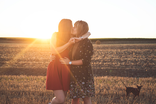Lesbian couple have fun on a cropped field