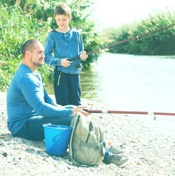 istock father and son fishing in wild river 830268200