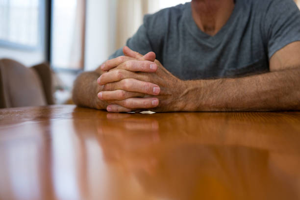 istock Midsection of senior man sitting at table 830305562