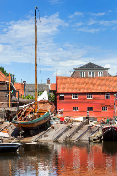 Historic shipyard with wooden fishing boat in the harbor of Spakenburg Historic shipyard with wooden fishing boat in the harbor of the village Spakenburg in the Netherlands. sailboat mast stock pictures, royalty-free photos & images