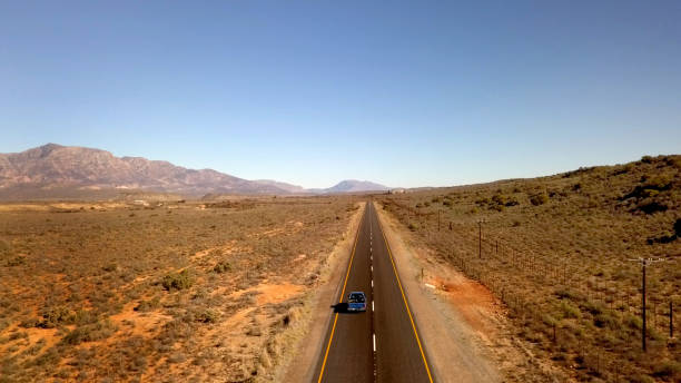 istock Car in arid landscape on long road 830331170