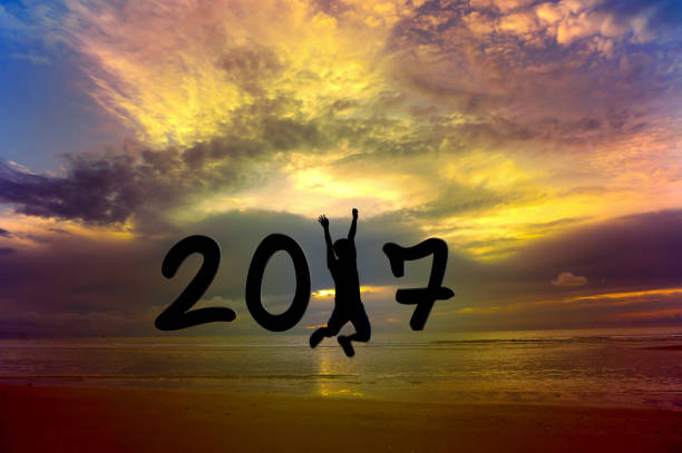 istock A man jumping on the beach at sunset and 2017 concept. 830338330