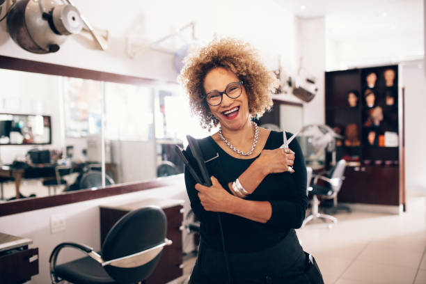 peluquería mujer en el salón sosteniendo herramientas peluquería - straightener fotografías e imágenes de stock