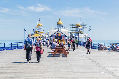 People walking and relaxing on the Pier of Eastbourne in East Sussex, United Kingdom