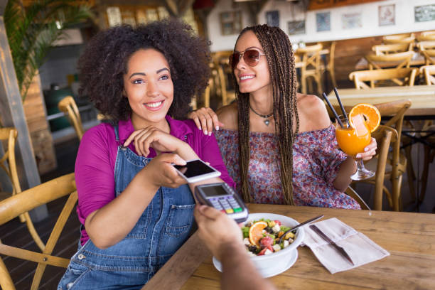 alegre frineds usando telefone inteligente para pagamento móvel - smart casual occupation casual healthy eating - fotografias e filmes do acervo