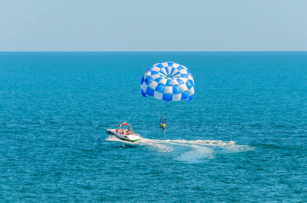 istock Blue parasail wing pulled by a boat in the sea water, Parasailing also known as parascending or parakiting 830358124