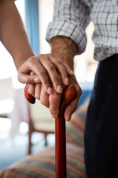 女医と老人ホームで歩行杖を保持している年配の男性の手 - human hand aging process senior adult cane ストックフォトと画像