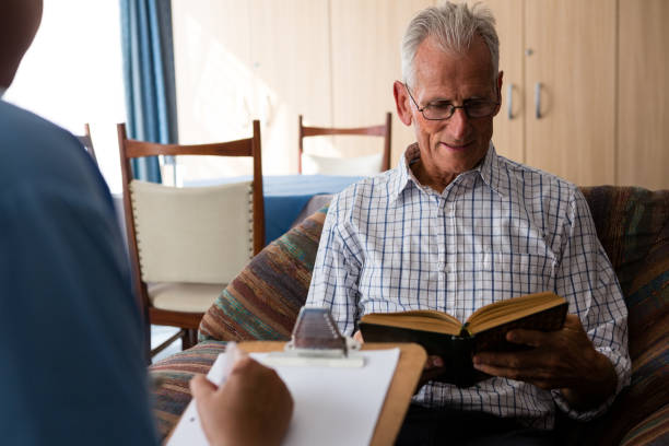 istock Doctor writing on paper while senior man reading book in nursing home 830364780