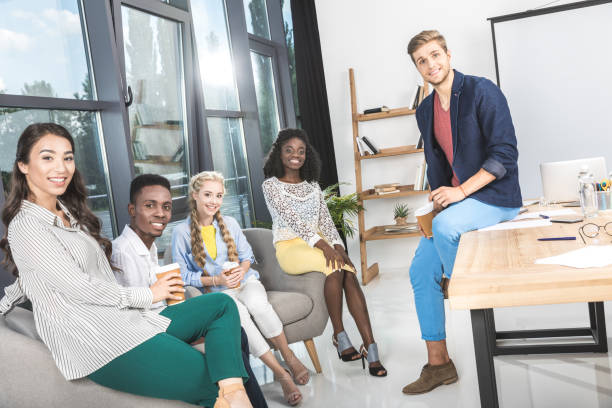 istock business coworkers looking at camera while having coffee break in office 830366096