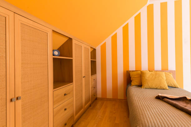 istock White and orange bedroom with small bed 830370624