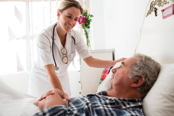 istock Doctor examining senior man lying on bed in nursing home 830372084