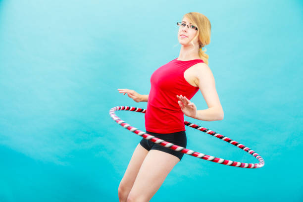 istock Fit woman with hula hoop doing exercise 830377560