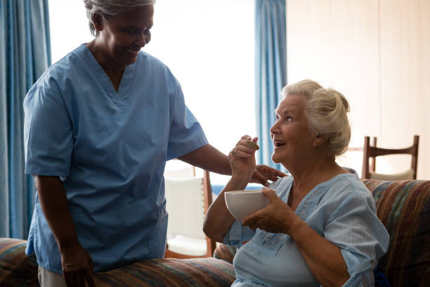 istock Senior woman talking to nurse while having food 830377576