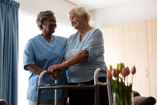 istock Nurse assisting senior patient in walking with walker 830385014