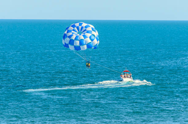 istock Blue parasail wing pulled by a boat in the sea water, Parasailing also known as parascending or parakiting 830385212