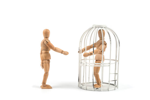 istock Wooden mannequin in cage / trap or prison 830385438