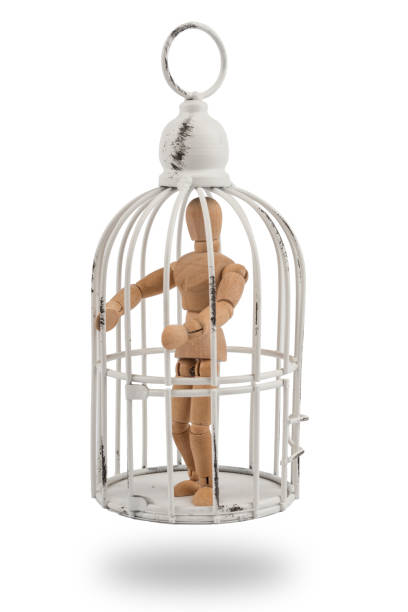 istock Wooden mannequin in cage / trap or prison 830387662