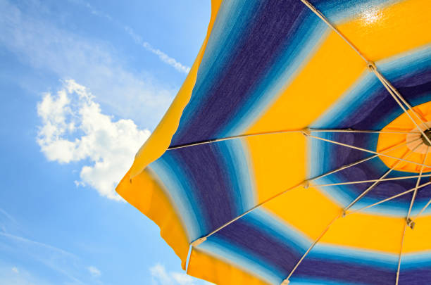istock Colored sun umbrella, blue sky, outdoor, half close up 830388300