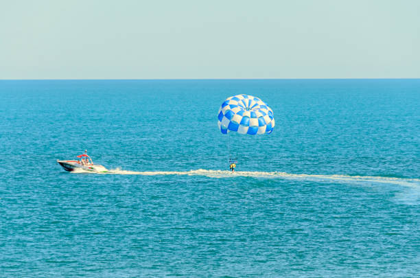 istock Blue parasail wing pulled by a boat in the sea water, Parasailing also known as parascending or parakiting 830400222