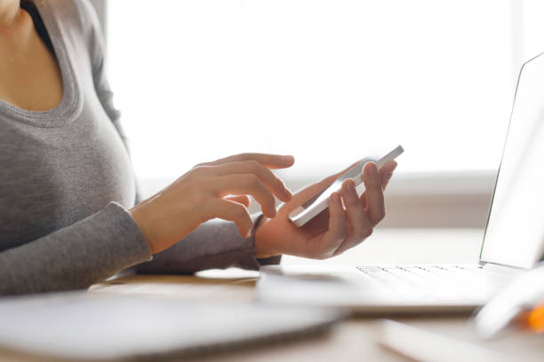 istock Hands working on the phone in front of the copmputer screen 830400878